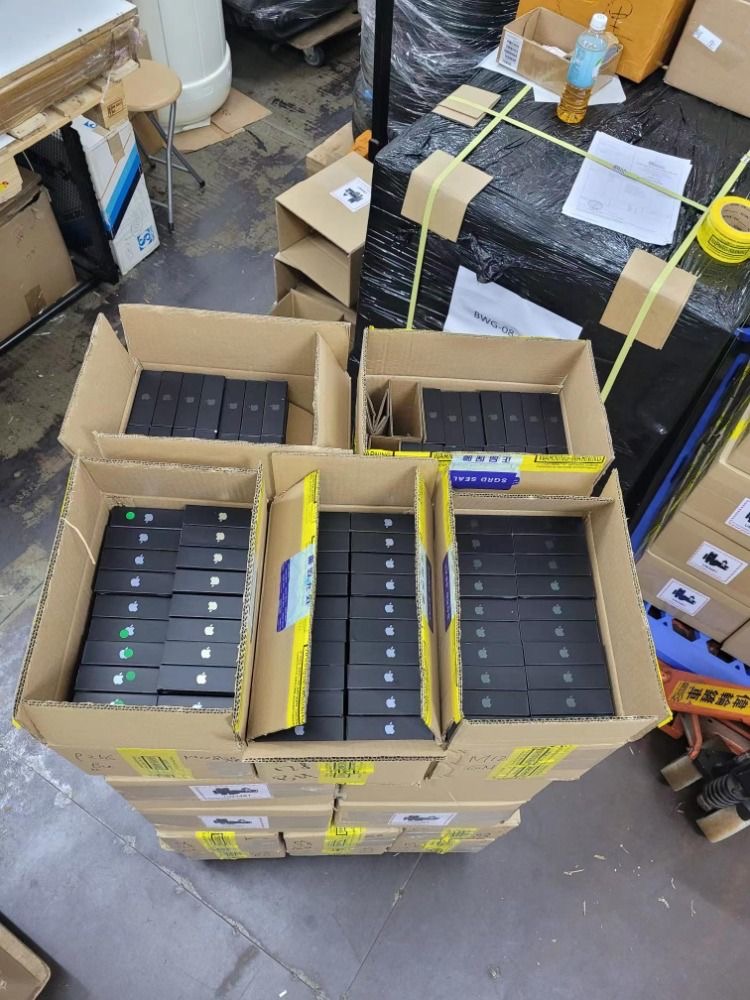 reseller inspecting iphone pallets